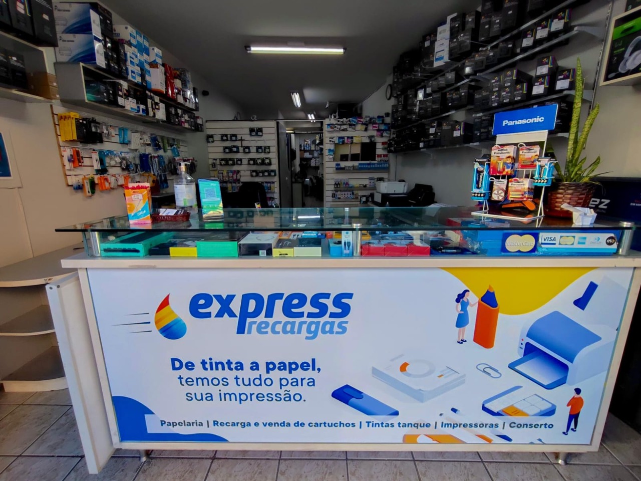 Visão ampla do balcão e interior da Express Recargas